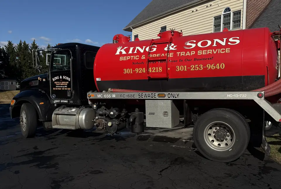 King and Sons septic pump truck with the family name on the tank, parked at a customer's home
