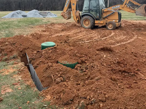King and Sons backhoe excavating for a septic system in a Maryland yard